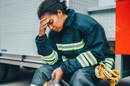 Unhappy firefighter sitting at the firefighter truck after failure on rescue operation