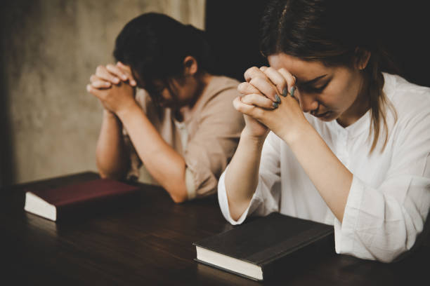 istock Two women praying worship believe 1405391921