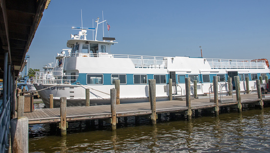 Bay Shore, New York, USA - 30 May 2022: Side view of a few Fire Island Ferry boats in their slips at the Bay Shore Ferry Terminal on Memorial Day 2022.