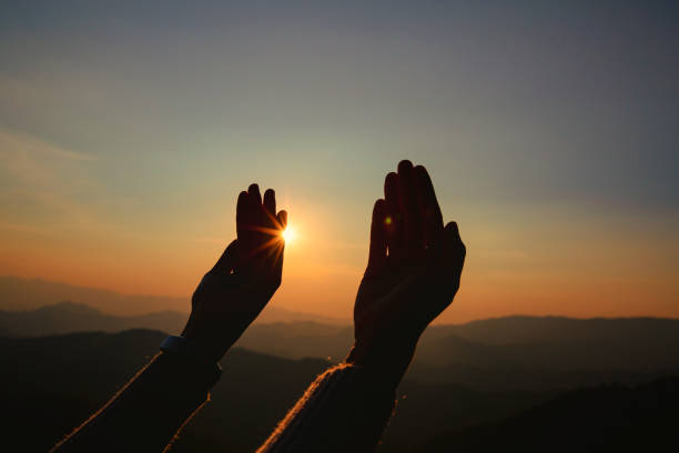 istock woman hands worship on sunset 1405392962