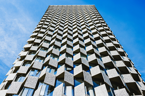 Low angle view on skyscraper exterior, concrete panels by the windows in pattern as architectural feature