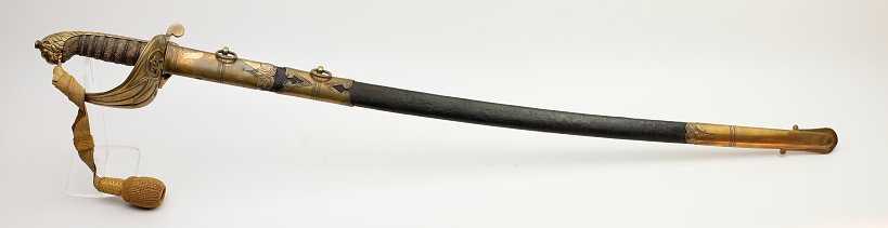 An antique British naval sabre from the Victorian period, in a private collection. It is made from steel, brass, gold and leather.