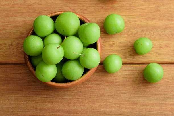 istock green plums in bowl on wooden table 1405393438