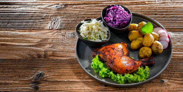 istock Baked chicken leg with potatoes and vegetable salads 1405393483