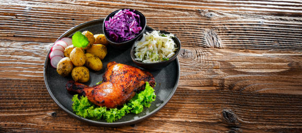 istock Baked chicken leg with potatoes and vegetable salads 1405393522