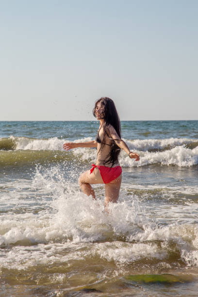 istock girl jumping in sea 1405394214