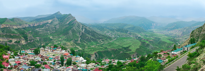 view of the village of Gunib on a mountainside and a foggy mountain valley behind it, North Caucasus landscape