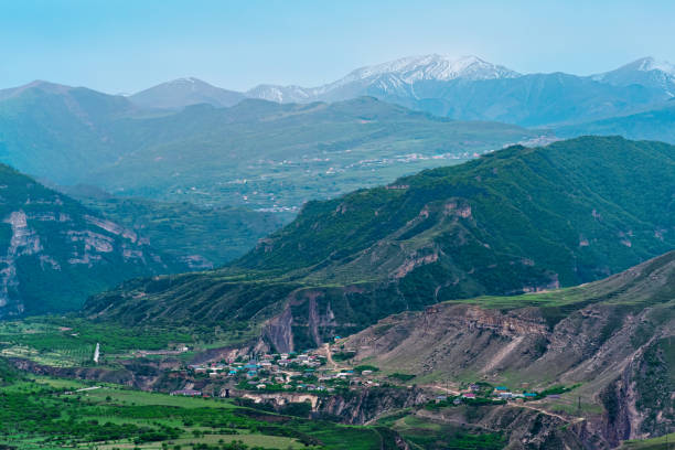 istock foggy alpine valley with settlements and fields between mountain peaks