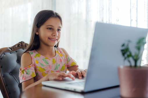 Child Girl Using Laptop Computer At Home