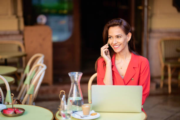 istock Brown haired woman sitting in a cafe and using her laptop 1405398230