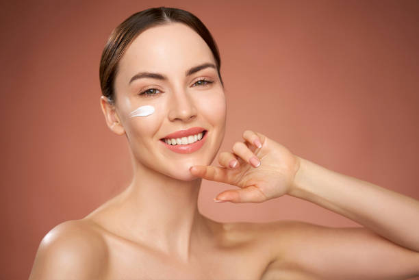 istock Happy woman with applied cream on face 1405398748