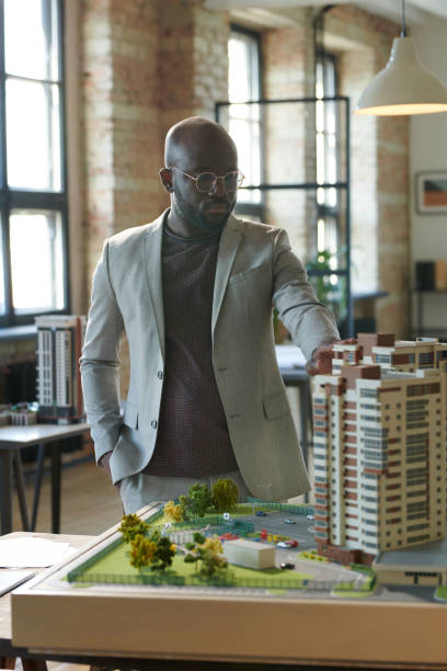 istock Architect examining mock-up of tower block 1405399304