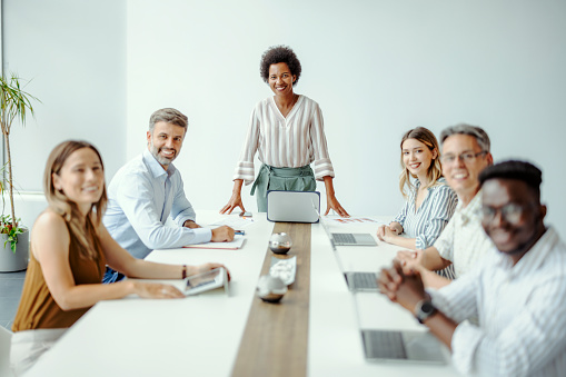 Black female entrepreneur with diverse colleagues looking at camera in a conference room