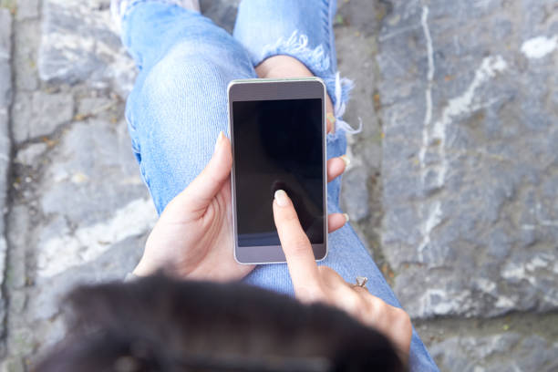 istock Woman in jeans using modern smartphone outdoors. 1405405132