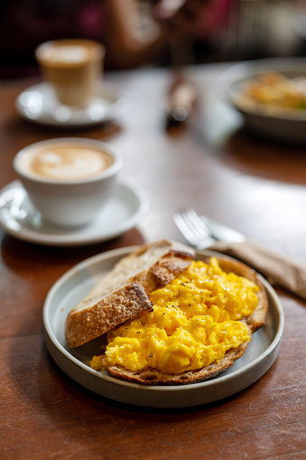 Light, Fluffy and Buttery Scrambled Eggs on Toast with a cup of coffee