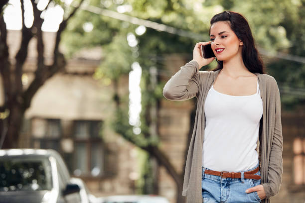 istock Young cute female using smartphone on the street. 1405405600