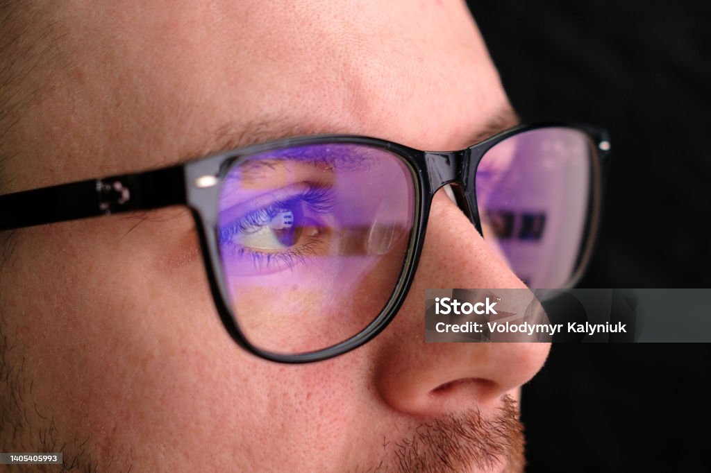 Man in the glasses watches to the monitor. Reflection in the googles Man in the glasses watches to the monitor. Reflection in the googles. Technology Stock Photo