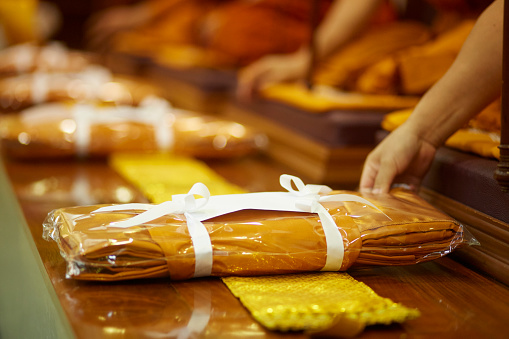 Give the offering a suit of yellow robes of a Buddhist monk, to do good things to create positive karma for oneself