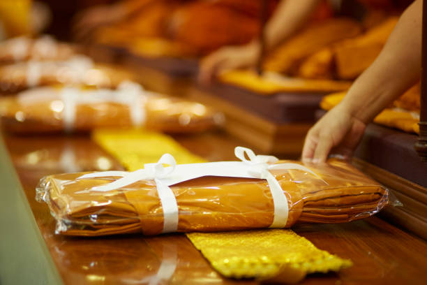 Give the offering Buddhist monk Give the offering a suit of yellow robes of a Buddhist monk, to do good things to create positive karma for oneself monk dress stock pictures, royalty-free photos & images