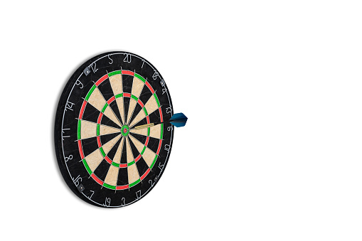 Dart board isolated on white background. Blue dart in the bullseye. Close-up. Front side view. Copy space. Success, competition and business concept.