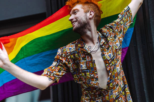 istock Young gay man waving with a rainbow flag 1405408898