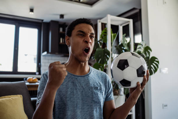 istock Young man watching a soccer game at home 1405412704