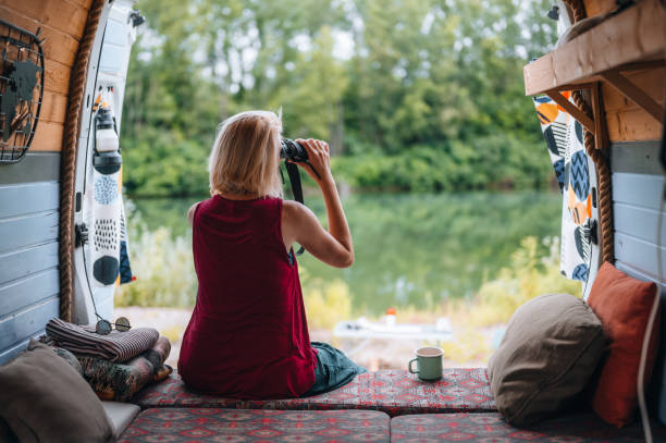 istock Rear view of a woman looks through binoculars from her van 1405413476