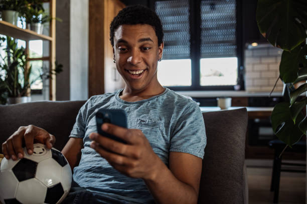 aficionado al fútbol que usa la aplicación móvil para apostar - match sport leisure games sport apps fotografías e imágenes de stock