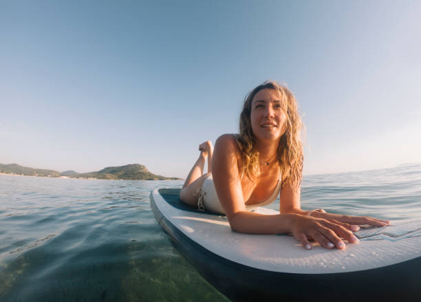 istock Woman sun tanning on paddle board 1405414096