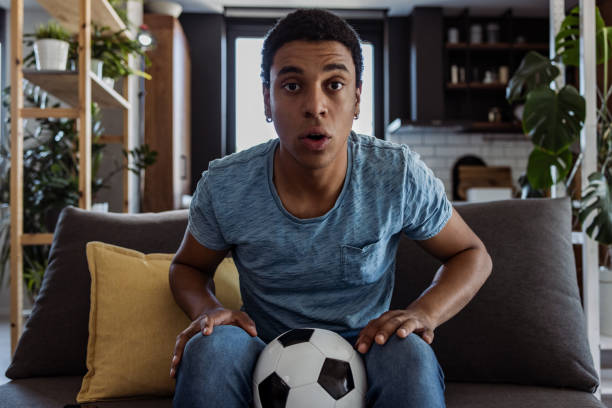 istock Focused black man supporting his favorite team at home 1405415175