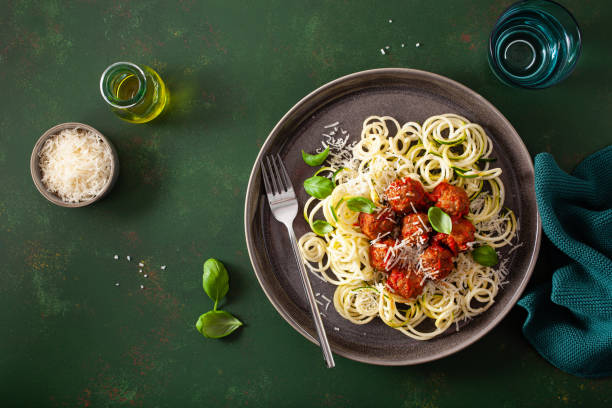 keto paleo diet zoodles spiralized zucchini noodles with meatballs and parmesan stock photo