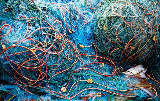 Several coloured fishing nets deposited in fishing boat