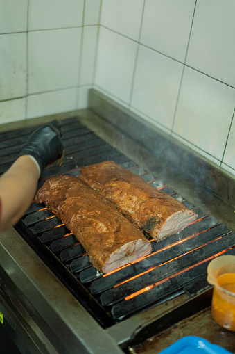 The cook of the Latin restaurant in Bogota Colombia between 50 and 59 years old, checks how the preparation of the food is going in the oven
