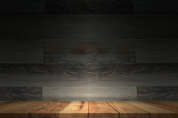 istock Empty wooden table on the dark background, perspective wooden floor shelf table used as a studio background wall to display your products 1405417743