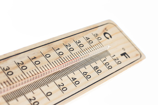 A wooden temperature thermometer isolated against a pure white background with red mercury