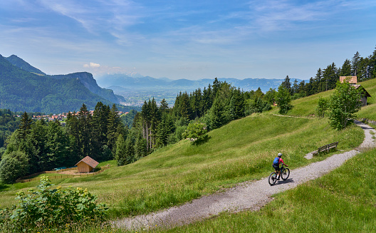 nice senior woman riding her electric mountain bike  in the Bregenzer Wald mountain range above Dornbirn and Rhine valley in Vorarlberg, Austria
