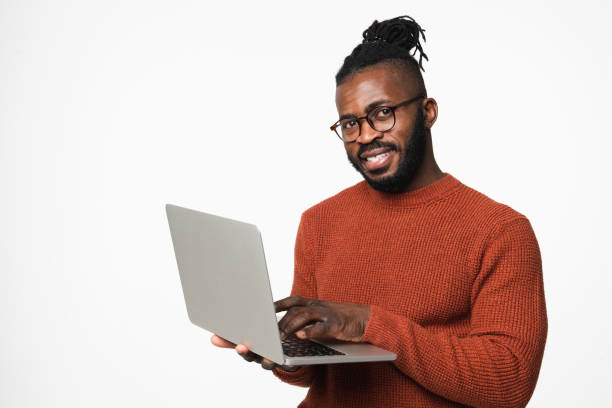 istock Young african-american businessman freelancer programmer typing working remotely on laptop, e-learning, watching webinars online isolated in white background 1405420309