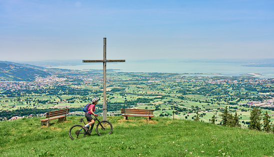 nice senior woman riding her electric mountain bike  in the Bregenzer Wald mountain range above Bregenz and Lake of Constance in Vorarlberg, Austria