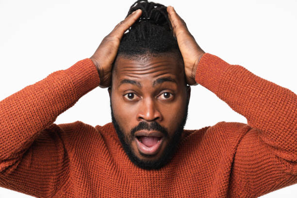 istock Closeup shocked impressed african-american young man in red sweater with dreadlocks shouting about sales offer discount isolated in white background 1405420930