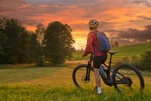 kobieta z rowerem elektrycznym o zachodzie słońca w austrii - bregenzwald zdjęcia i obrazy z banku zdjęć