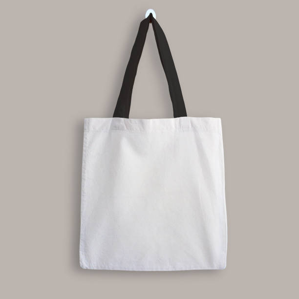 White blank cotton eco tote bag with black straps, design mockup White blank cotton eco tote bag with black straps, design mockup. Shopping bag hanging on wall. strap photos stock pictures, royalty-free photos & images