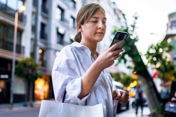 Young woman calls an Uber after shopping stock photo