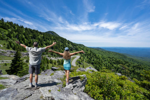 istock Couple with outstretched arms in summer mountain scenery. 1405432162