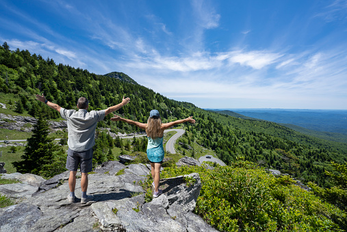 Joyful people with raised arms on top of the mountain. Near Asheville. ,Grandfather Mountain State Park, North Carolina, USA.