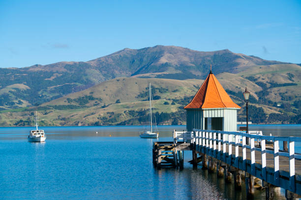 The landmark of Akaroa, Daly's Wharf at sunset. The landmark of Akaroa, Daly's Wharf at sunset. river wharfe stock pictures, royalty-free photos & images