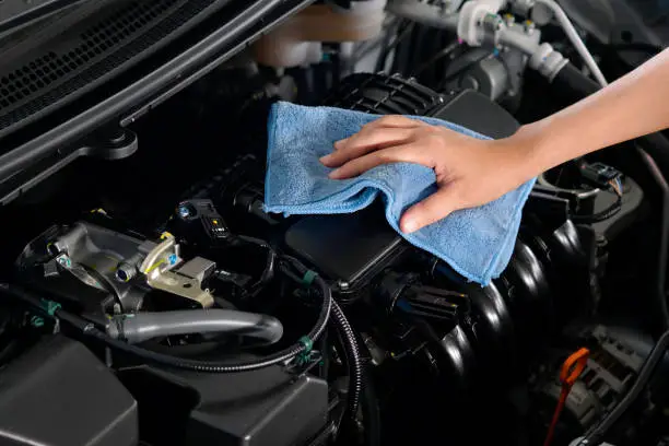 Photo of hand of a man holding a blue cloth caring, maintenance car and cleaning And engine car room