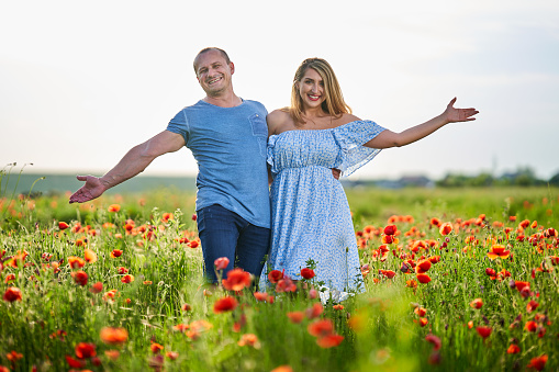 Mixed race couple having fun in a poppy field