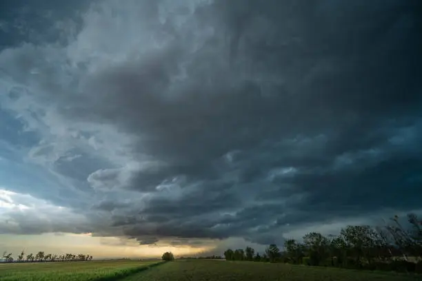 Dramatic sky over rural landscape, agricultural fields, approaching thunderstorm with dark storm clouds