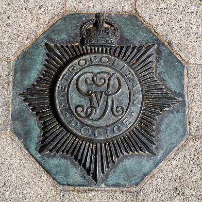 London, UK - 16th April 2022: Crown emblam for the Metropolitan Police service, embedded in the pavement outside of the New Scotland Yard building, Victoria Embankment, London.