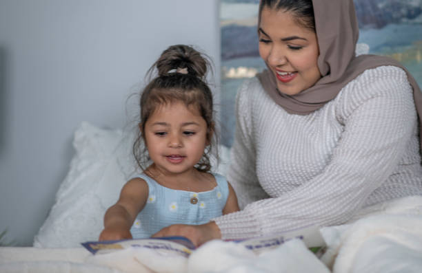 istock Muslim Mother and Daughter Reading 1405436415